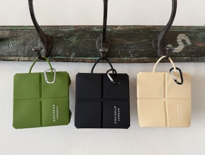 Cocopup London foldable silicone travel dog bowls – khaki, black & nude, collapsed together on a carabiner clip