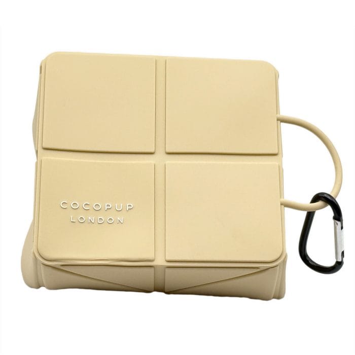 Cocopup London foldable silicone travel dog bowl – nude, collapsed flat with branding and carabiner loop detail