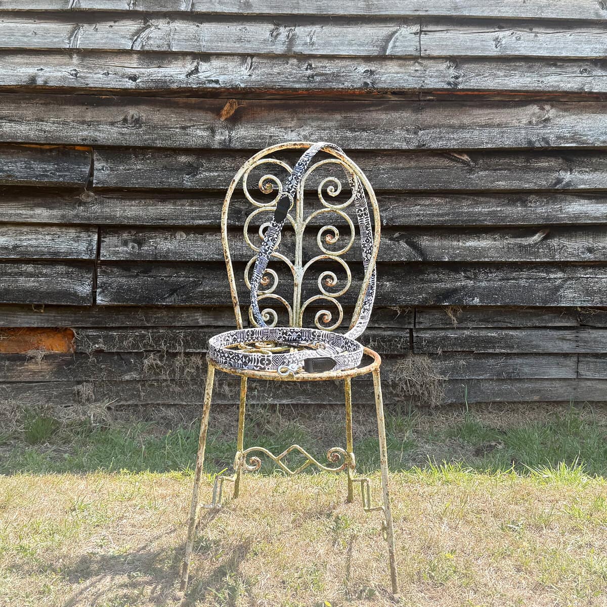 Hiro + Wolf patterned dog leash displayed on a vintage chair in front of a rustic wooden wall