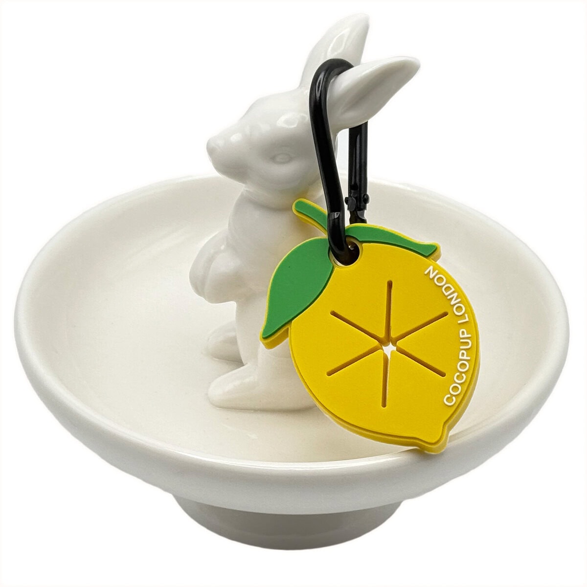 CP-DOG-0001-LE_Poop Pocket_Lemon copy Cocopup London Lemon Poop Pocket, bright yellow dog waste bag holder with green leaf detail, shown with a black carabiner clip, displayed on a white ceramic rabbit dish.