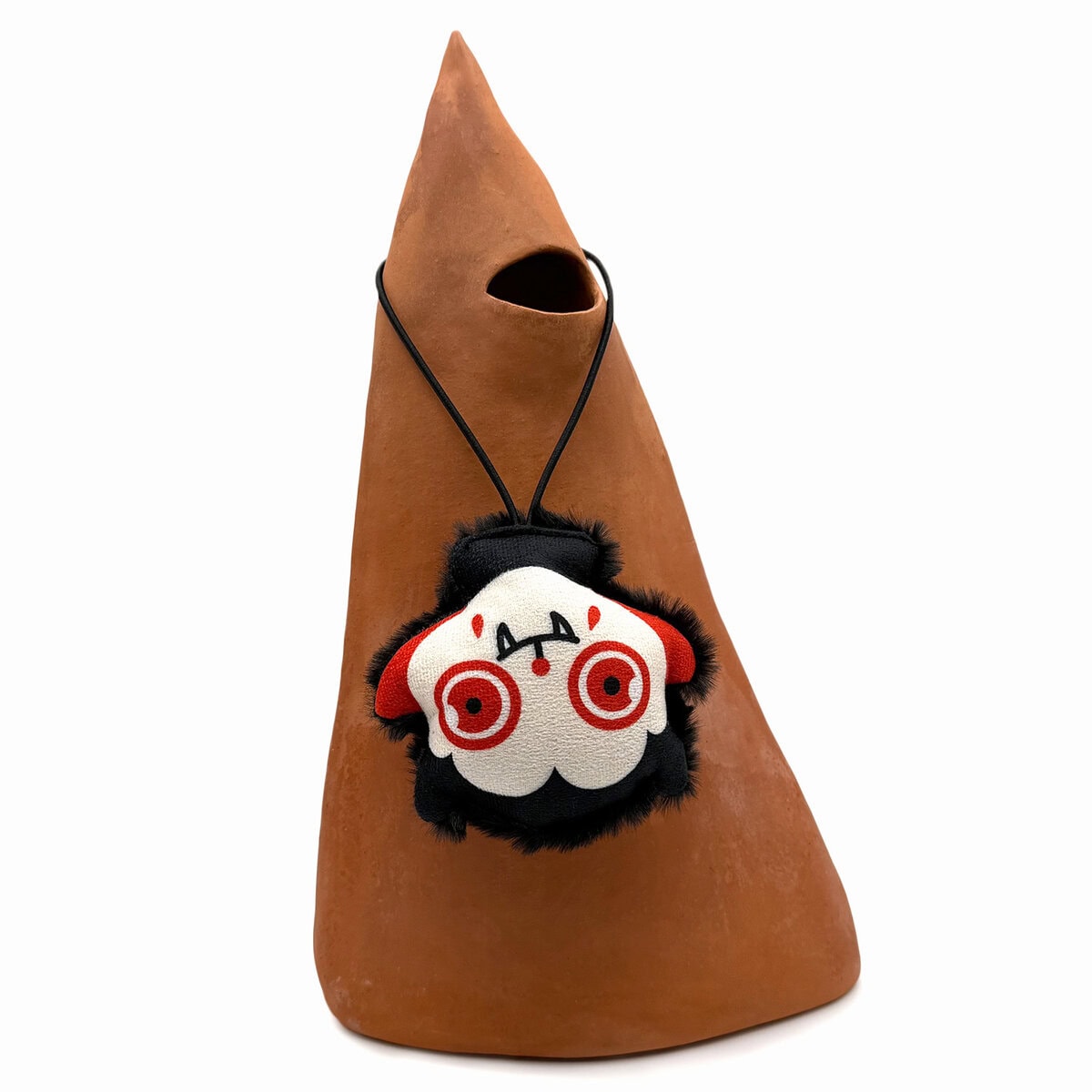 WW-CAT-0002-va_Image copy WufWuf Mymeow Vampurr Teaser Cat Toy, plush vampire cat character with red eyes and fangs, displayed hanging upside down on a terracotta ornament, shown in a styled image.