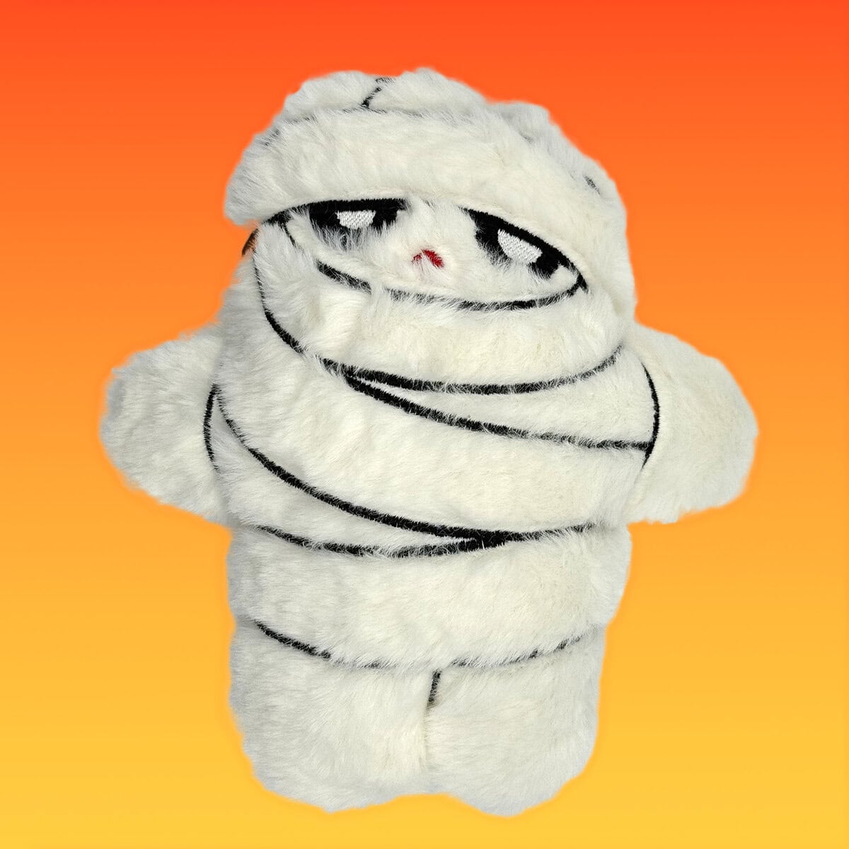 WW-DOG-0001-Mummy_Front Orange WufWuf “Mummy” crinkle plush dog toy – white plush mummy character with stitched black eyes and red nose, set against an orange-yellow gradient background for a Halloween-themed presentation.