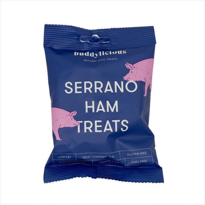 Blue Buddylicious Serrano Ham Treats dog snack bag with pink pig illustrations and white text, natural semi-moist treats rich in omega oils – EdenWave.